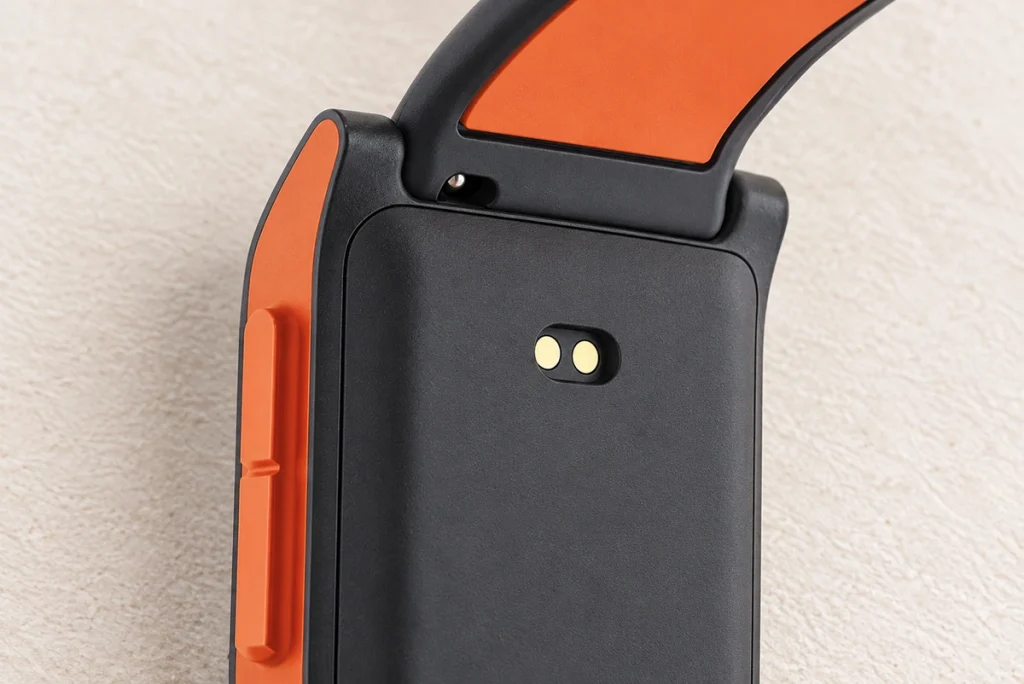Two rear charging contact pads on the original black and orange wearable case.