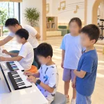Family interacting with unbranded piano learning machines in a bright music play room.