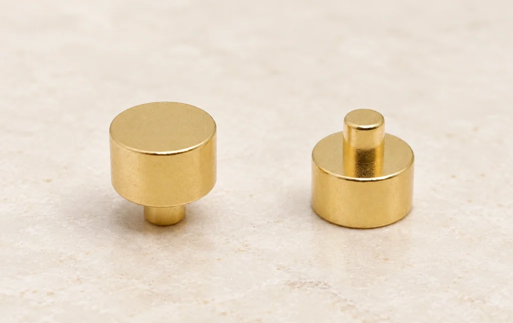Two solid gold stepped cylindrical contact parts with opposite stem orientations.