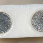 Two circular charging contacts showing surface corrosion.