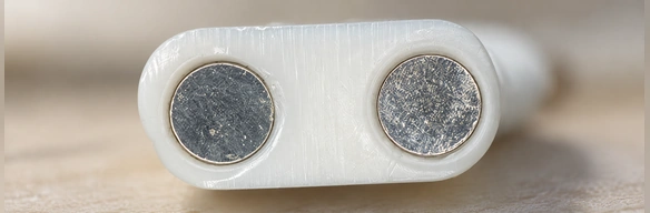 Two circular charging contacts showing surface corrosion.