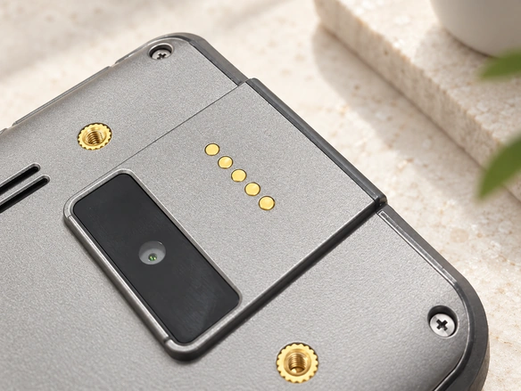 Five charging contacts on the underside of a device housing.