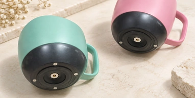 Pink and green temperature-control cups showing circular central and ring charging contacts.