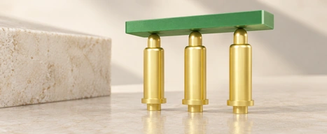 Three gold spring pins touching a green circuit board.